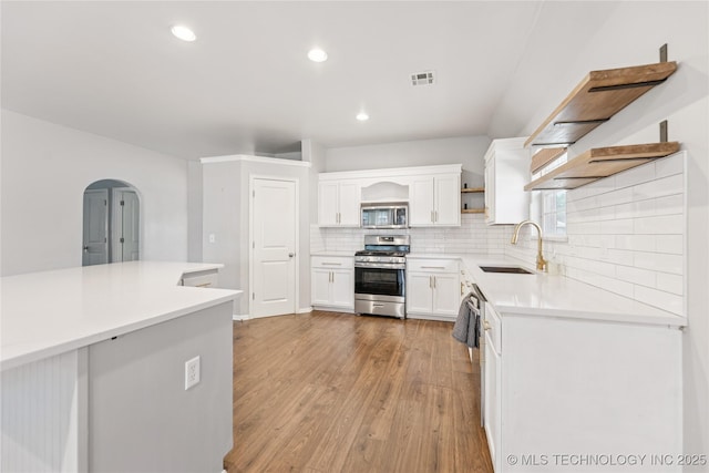 2105 W D Ct, Jenks, OK 74037 - kitchen featuring stainless steel appliances, open shelves, backsplash, white cabinetry, and light wood finished floors