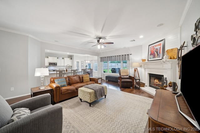 701 E 119th St, Jenks, OK 74037 - living area featuring wood finished floors, a ceiling fan, crown molding, a fireplace, and recessed lighting