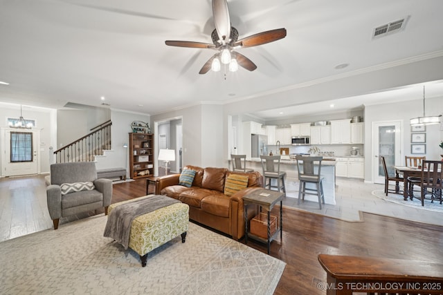 701 E 119th St, Jenks, OK 74037 - living area featuring light wood-type flooring, stairway, a ceiling fan, a chandelier, and recessed lighting