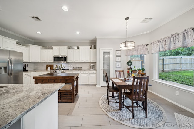 701 E 119th St, Jenks, OK 74037 - kitchen with appliances with stainless steel finishes, decorative backsplash, white cabinetry, ornamental molding, and hanging light fixtures