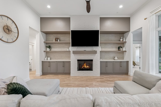 6684 E 128th St S, Bixby, OK 74008 - living area featuring light wood-style flooring, a brick fireplace, crown molding, recessed lighting, and built in shelves