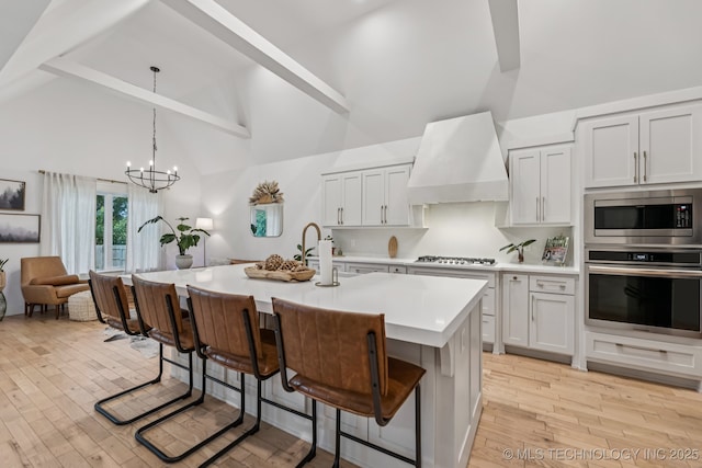 6684 E 128th St S, Bixby, OK 74008 - kitchen featuring stainless steel appliances, premium range hood, high vaulted ceiling, light countertops, and light wood-type flooring