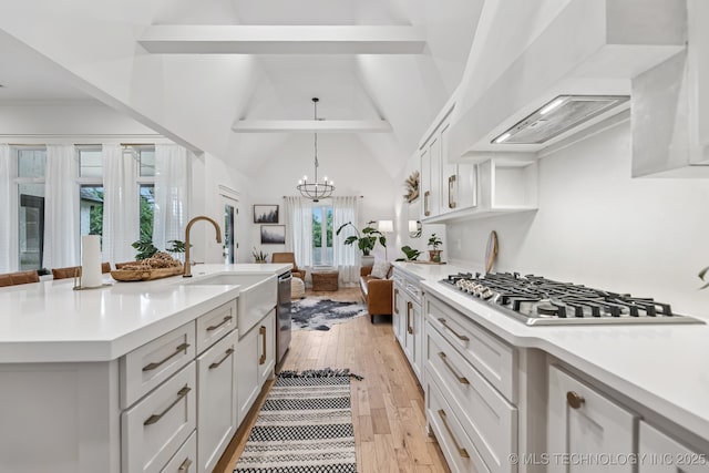 6684 E 128th St S, Bixby, OK 74008 - kitchen with wall chimney exhaust hood, stainless steel appliances, light countertops, beam ceiling, and light wood-style floors