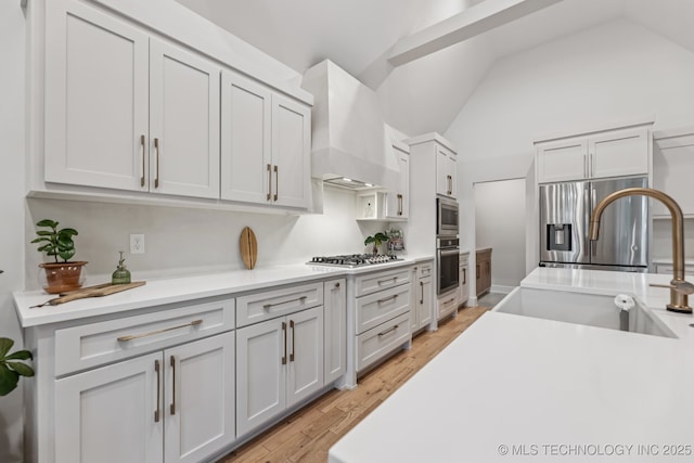 6684 E 128th St S, Bixby, OK 74008 - kitchen featuring wall chimney exhaust hood, stainless steel appliances, light countertops, light wood-style floors, and lofted ceiling