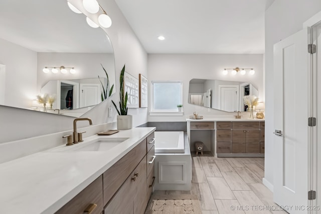 6684 E 128th St S, Bixby, OK 74008 - bathroom with two vanities, a bath, and recessed lighting