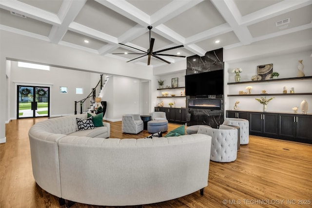 17076 S 31st E Ave, Mounds, OK 74047 - living room featuring coffered ceiling, stairs, beamed ceiling, a premium fireplace, and light wood-style floors