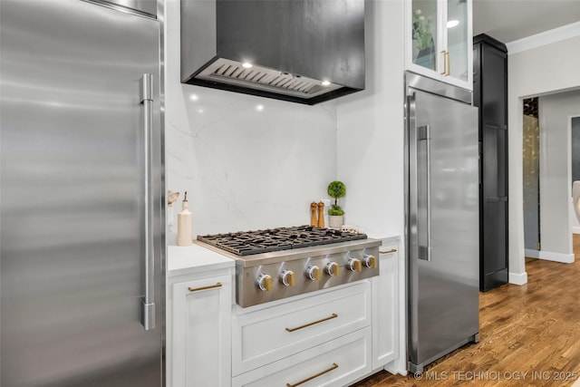 17076 S 31st E Ave, Mounds, OK 74047 - kitchen featuring appliances with stainless steel finishes, range hood, light countertops, glass insert cabinets, and wood finished floors