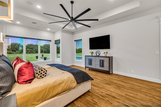 17076 S 31st E Ave, Mounds, OK 74047 - bedroom featuring wood finished floors, a tray ceiling, recessed lighting, and ceiling fan