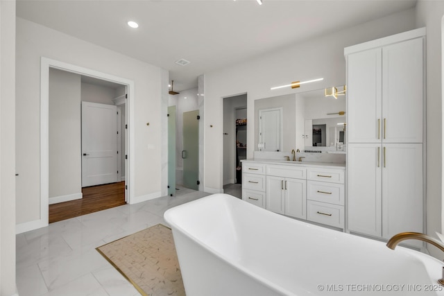 17076 S 31st E Ave, Mounds, OK 74047 - full bathroom with marble look tiles, a shower stall, a freestanding bath, vanity, and a closet