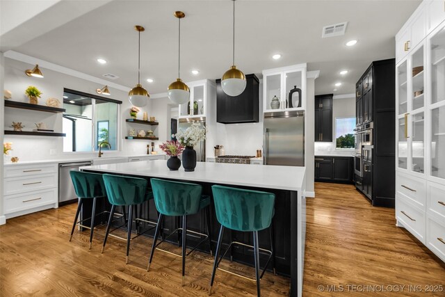 17076 S 31st E Ave, Mounds, OK 74047 - kitchen with stainless steel appliances, open shelves, healthy amount of natural light, a kitchen island, and ornamental molding