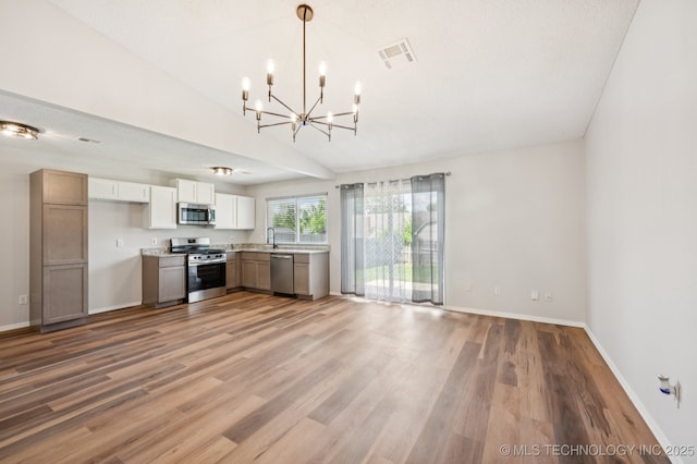208 183rd E Ave, Tulsa, OK 74108 - kitchen with appliances with stainless steel finishes, a chandelier, light countertops, light wood-type flooring, and white cabinets