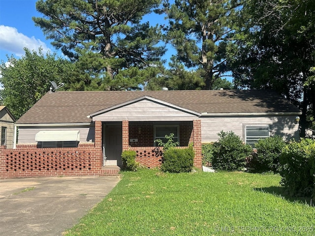 1208 S 9th, Mcalester, OK 74501 - view of front of home featuring a front yard, brick siding, covered porch, and roof with shingles