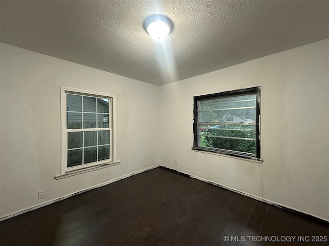 1208 S 9th, Mcalester, OK 74501 - empty room with dark wood finished floors and a textured ceiling