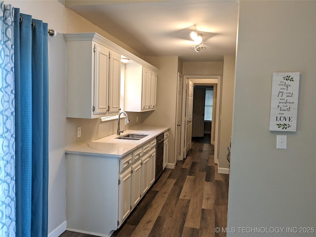605 W 18th St S, Claremore, OK 74019 - kitchen featuring light countertops, dark wood finished floors, dishwashing machine, and white cabinetry