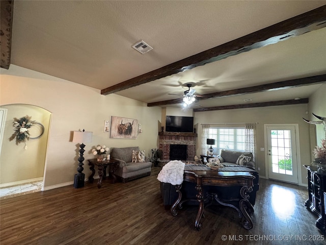 21902 W 13th St S, Sand Springs, OK 74063 - living area featuring wood finished floors, ceiling fan, a fireplace, beam ceiling, and arched walkways