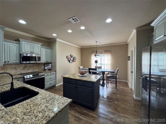 21902 W 13th St S, Sand Springs, OK 74063 - kitchen featuring appliances with stainless steel finishes, a center island, dark wood-style floors, backsplash, and a textured ceiling