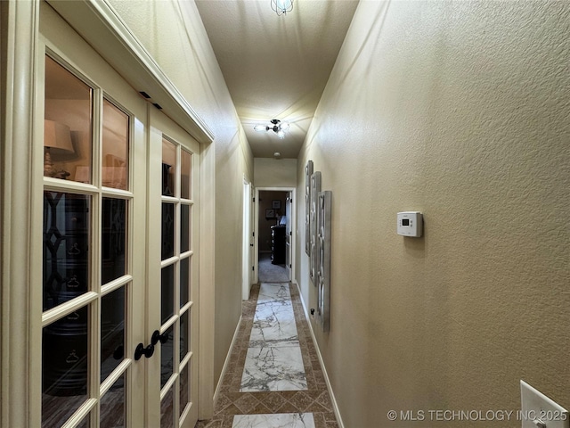 21902 W 13th St S, Sand Springs, OK 74063 - hallway with marble look tiles, french doors, and a textured wall