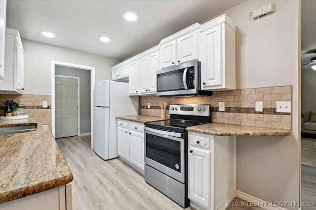 3948 S 93rd E Ave, Tulsa, OK 74145 - kitchen featuring appliances with stainless steel finishes, white cabinets, decorative backsplash, light wood-type flooring, and recessed lighting