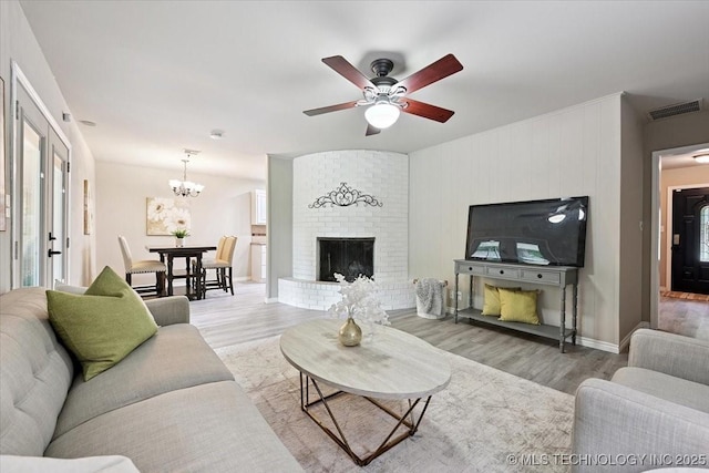 3948 S 93rd E Ave, Tulsa, OK 74145 - living area featuring wood finished floors, a ceiling fan, a chandelier, and a fireplace