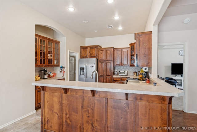 7440 E Indianola St, Broken Arrow, OK 74014 - kitchen with stainless steel refrigerator with ice dispenser, tasteful backsplash, a peninsula, brown cabinetry, and recessed lighting