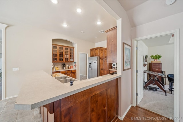 7440 E Indianola St, Broken Arrow, OK 74014 - kitchen with stainless steel fridge, a peninsula, glass insert cabinets, brown cabinets, and recessed lighting