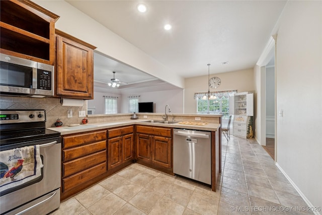 7440 E Indianola St, Broken Arrow, OK 74014 - kitchen with stainless steel appliances, a peninsula, brown cabinets, light countertops, and recessed lighting