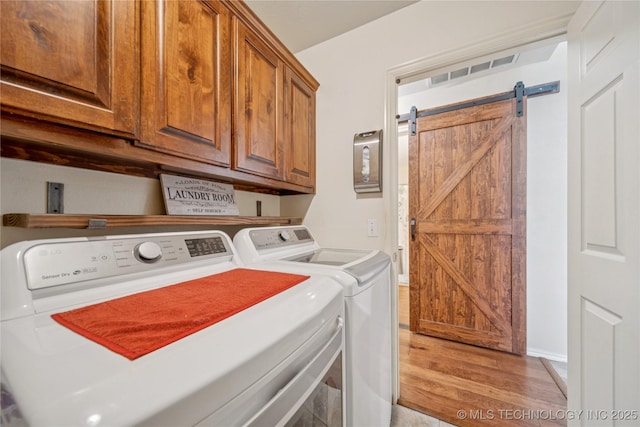7440 E Indianola St, Broken Arrow, OK 74014 - laundry area featuring independent washer and dryer, light wood-style flooring, cabinet space, and a barn door