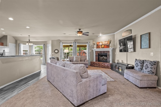 14908 E 88th St, Owasso, OK 74055 - living room featuring a brick fireplace, a chandelier, recessed lighting, ceiling fan, and ornamental molding