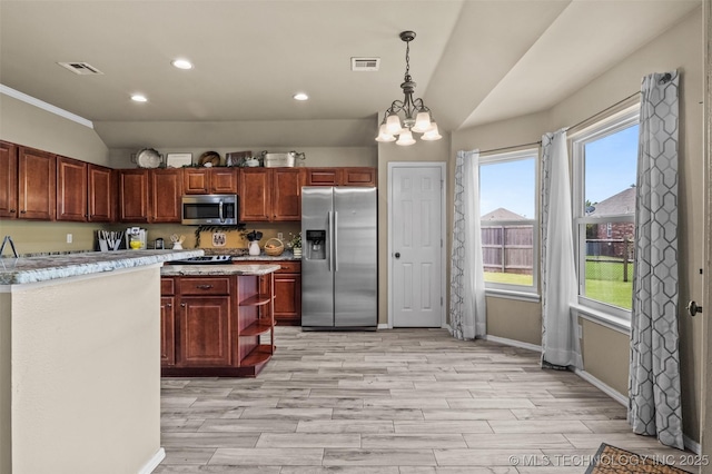 14908 E 88th St, Owasso, OK 74055 - kitchen featuring appliances with stainless steel finishes, light countertops, a chandelier, lofted ceiling, and light wood finished floors