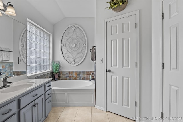 14908 E 88th St, Owasso, OK 74055 - bathroom featuring vanity, tile patterned flooring, a garden tub, and vaulted ceiling