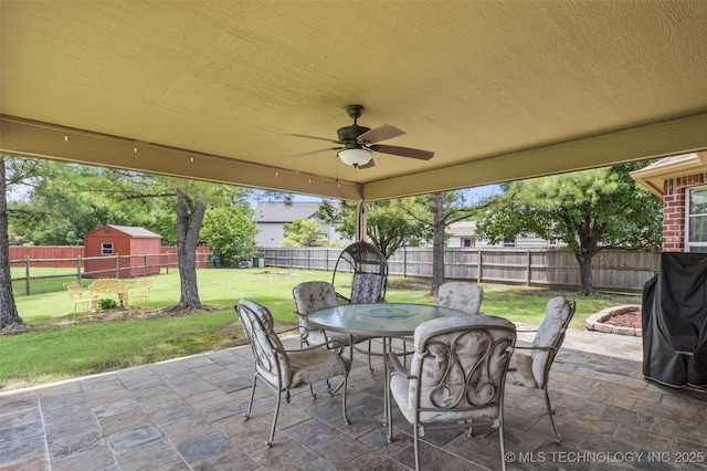14908 E 88th St, Owasso, OK 74055 - fenced backyard featuring outdoor dining space, a patio, a ceiling fan, and a storage shed