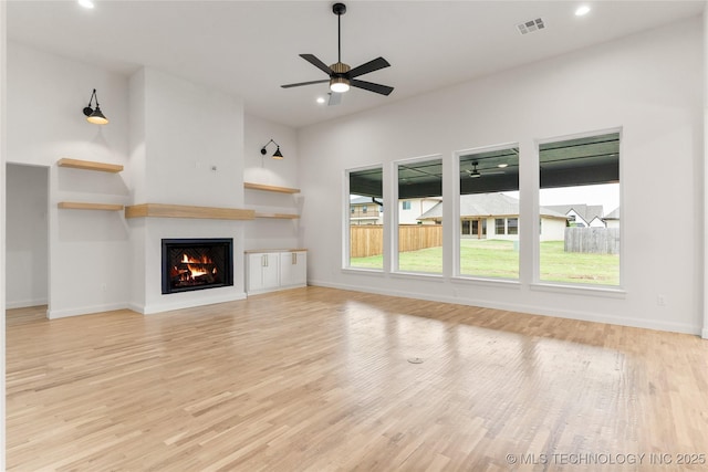 2985 E 146th St S, Bixby, OK 74008 - unfurnished living room with light wood-style flooring, a warm lit fireplace, recessed lighting, and a ceiling fan