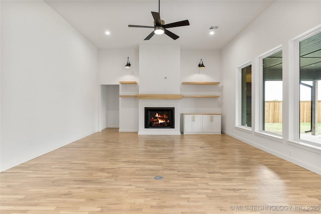 2985 E 146th St S, Bixby, OK 74008 - unfurnished living room with light wood finished floors, a lit fireplace, ceiling fan, and recessed lighting