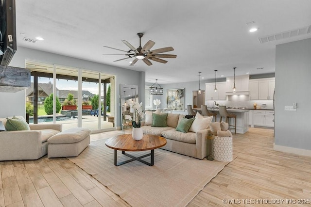 19021 E Chokeberry St, Owasso, OK 74055 - living area with a ceiling fan, light wood-type flooring, recessed lighting, and a chandelier