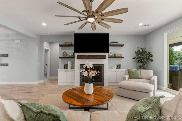 19021 E Chokeberry St, Owasso, OK 74055 - living room with a ceiling fan, a tiled fireplace, recessed lighting, and light wood-style flooring