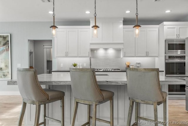 19021 E Chokeberry St, Owasso, OK 74055 - kitchen with white cabinetry, decorative backsplash, hanging light fixtures, and recessed lighting