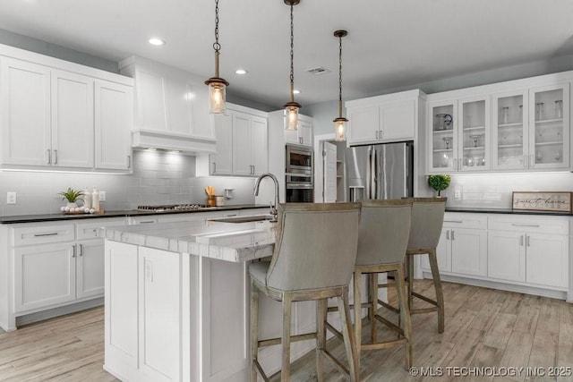 19021 E Chokeberry St, Owasso, OK 74055 - kitchen with appliances with stainless steel finishes, decorative backsplash, white cabinetry, recessed lighting, and light wood-type flooring