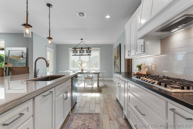 19021 E Chokeberry St, Owasso, OK 74055 - kitchen featuring appliances with stainless steel finishes, decorative backsplash, light wood-style floors, white cabinets, and dark stone countertops