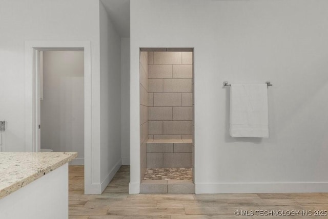 19021 E Chokeberry St, Owasso, OK 74055 - bathroom with wood finished floors, vanity, and a tile shower
