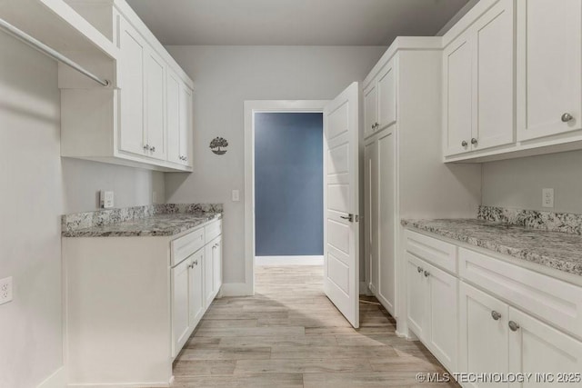 19021 E Chokeberry St, Owasso, OK 74055 - kitchen featuring light wood-style floors, white cabinetry, and light stone counters