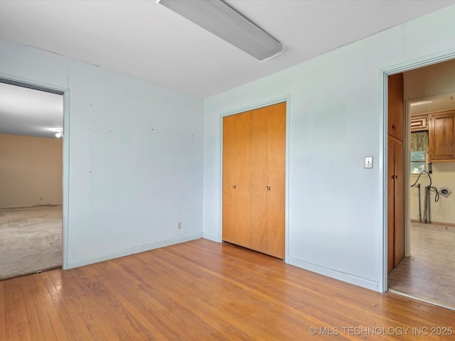 123 S Madison Blvd, Bartlesville, OK 74006 - unfurnished bedroom featuring light wood-style floors and a closet
