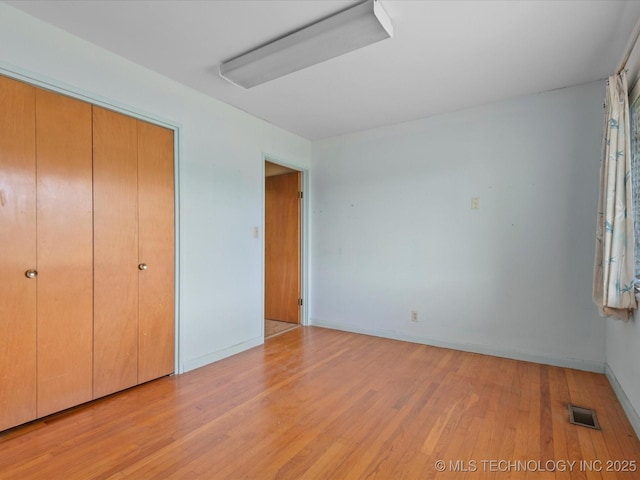 123 S Madison Blvd, Bartlesville, OK 74006 - unfurnished bedroom featuring light wood-style floors and a closet