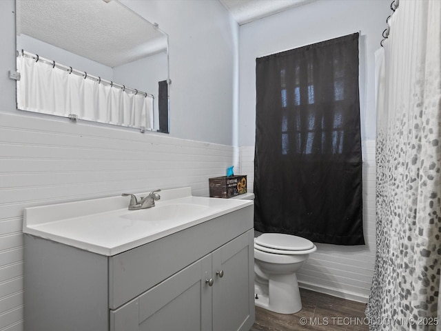 105 E Brahma Ave, Dewey, OK 74029 - full bath with wood finished floors, vanity, a textured ceiling, a wainscoted wall, and curtained shower