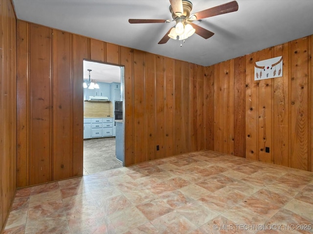 105 E Brahma Ave, Dewey, OK 74029 - spare room with wood walls and a ceiling fan