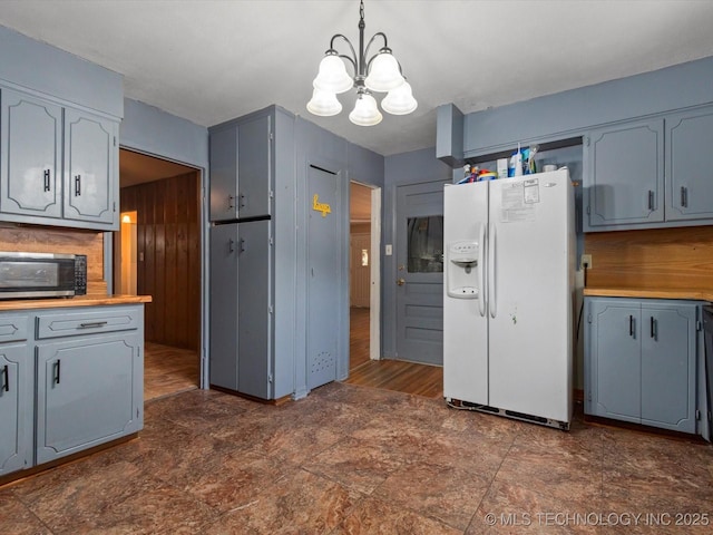 105 E Brahma Ave, Dewey, OK 74029 - kitchen featuring white fridge with ice dispenser, stainless steel microwave, a chandelier, and gray cabinetry