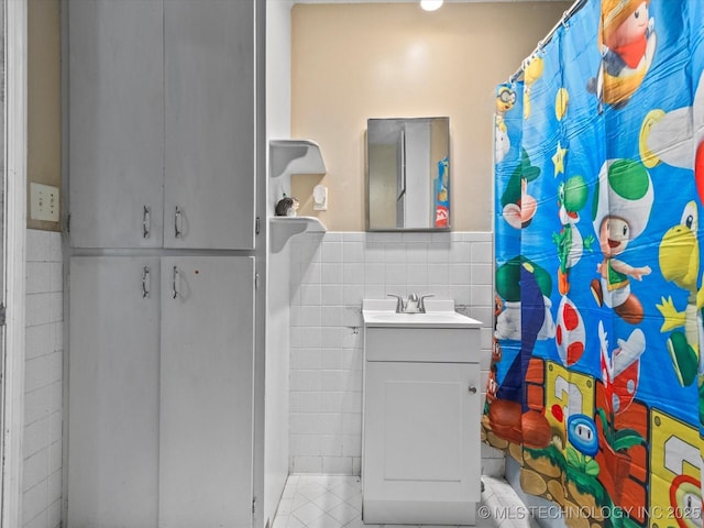 105 E Brahma Ave, Dewey, OK 74029 - full bath with tile walls, vanity, tile patterned flooring, a shower with shower curtain, and a wainscoted wall