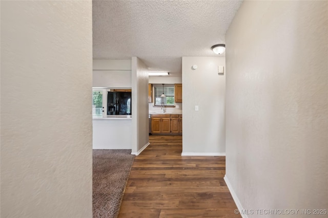 612 S 5th St, Eufaula, OK 74432 - corridor featuring dark wood-style flooring, a textured ceiling, and a textured wall