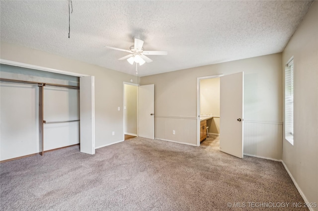 612 S 5th St, Eufaula, OK 74432 - unfurnished bedroom with carpet floors, a textured ceiling, a closet, connected bathroom, and ceiling fan