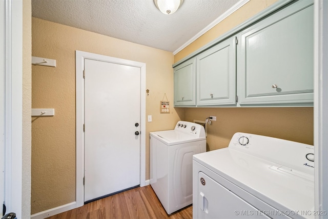 11017 E 98th St N, Owasso, OK 74055 - laundry area with cabinet space, washing machine and dryer, light wood-style floors, a textured ceiling, and a textured wall