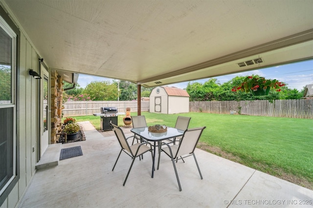 11017 E 98th St N, Owasso, OK 74055 - fenced backyard featuring a patio, outdoor dining space, a storage unit, and grilling area